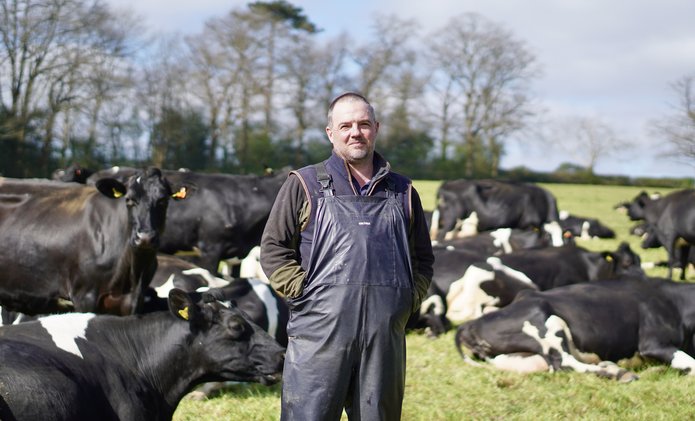 dairy farmer in field with cows