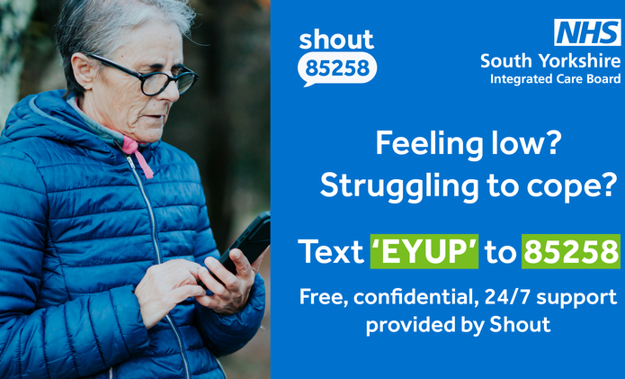 Text EYUP to 85258 older woman in puffer winter jacket on her mobile phone outdoors