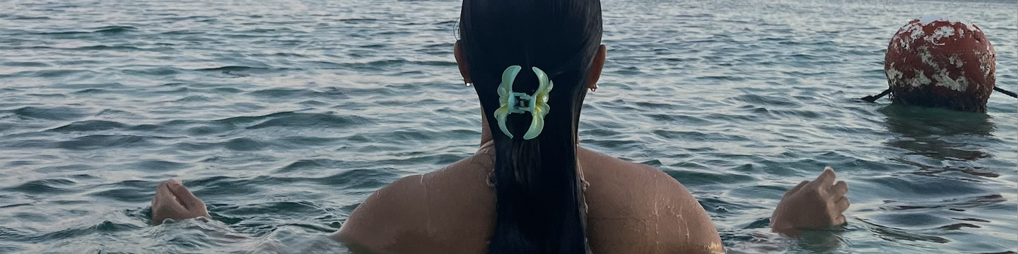 Back of woman with dark hair swimming in the sea