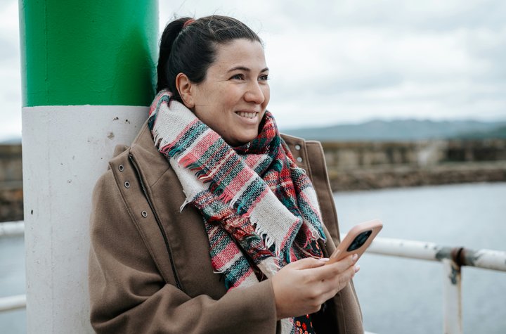 woman-smiling-phone-coastline
